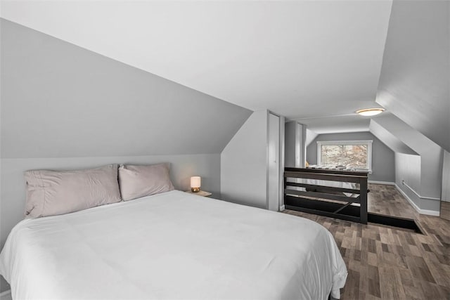 bedroom featuring vaulted ceiling, baseboards, and wood finished floors