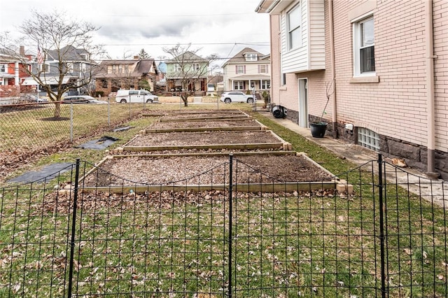 view of yard with a garden, a residential view, and fence