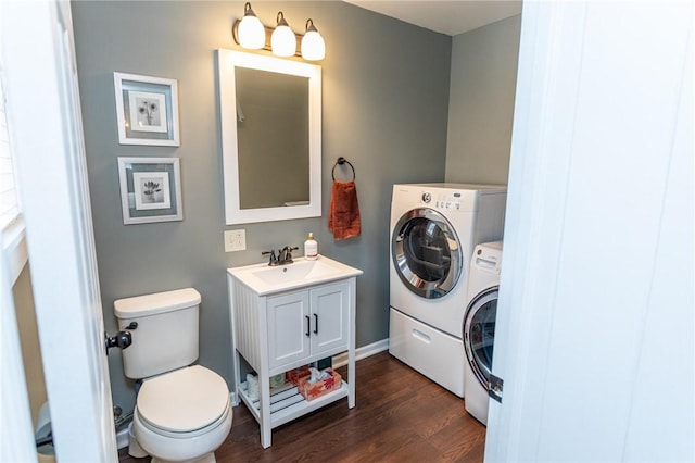 bathroom with wood finished floors, vanity, toilet, and separate washer and dryer