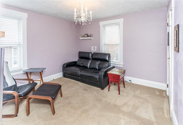 carpeted living area with a chandelier, a textured ceiling, and baseboards