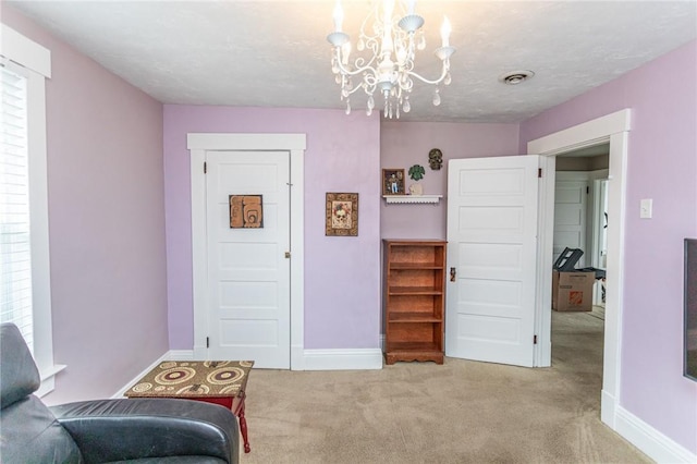 living area featuring a chandelier, carpet, visible vents, and baseboards