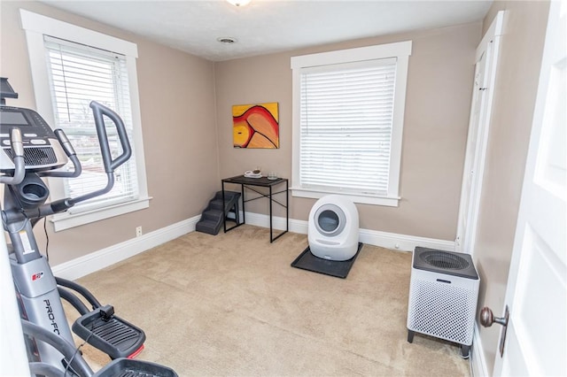 workout room featuring carpet and baseboards