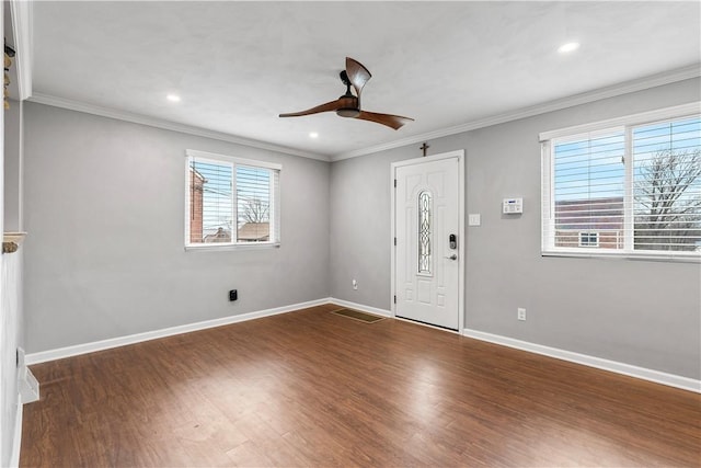 foyer entrance featuring ornamental molding, ceiling fan, baseboards, and wood finished floors