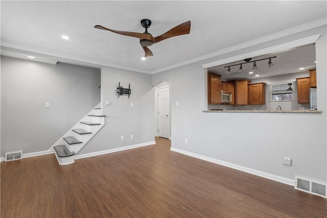 unfurnished living room featuring ornamental molding, dark wood-style flooring, visible vents, and baseboards