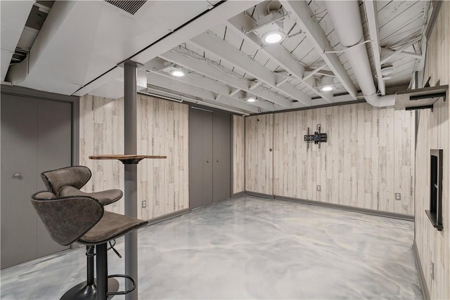 finished basement with wooden walls and visible vents