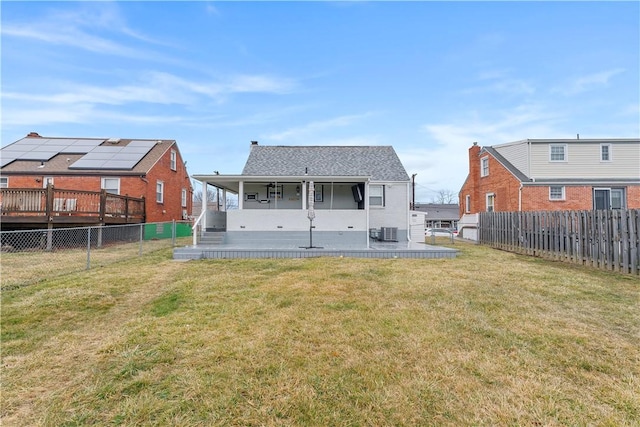 rear view of property featuring a fenced backyard, cooling unit, and a yard