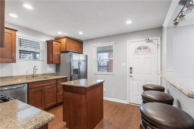 kitchen with dark wood-style floors, appliances with stainless steel finishes, a center island, a sink, and recessed lighting