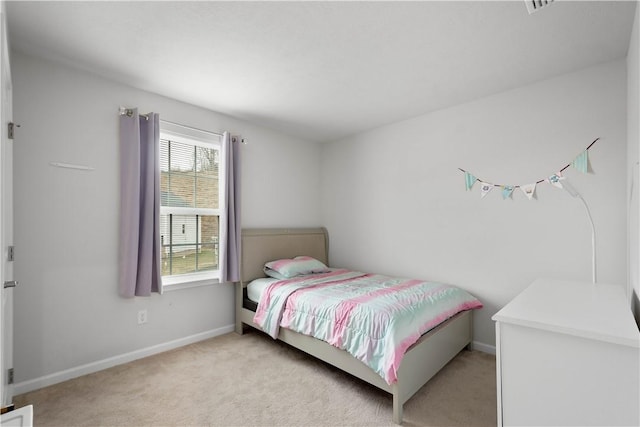 bedroom with light carpet and baseboards