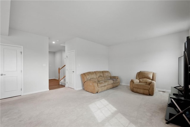 living area with recessed lighting, stairway, carpet, and baseboards