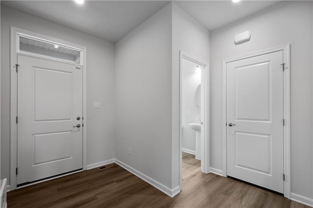 foyer with dark wood finished floors and baseboards