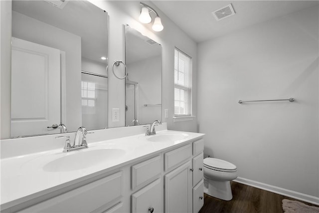 full bathroom featuring visible vents, a sink, toilet, and wood finished floors