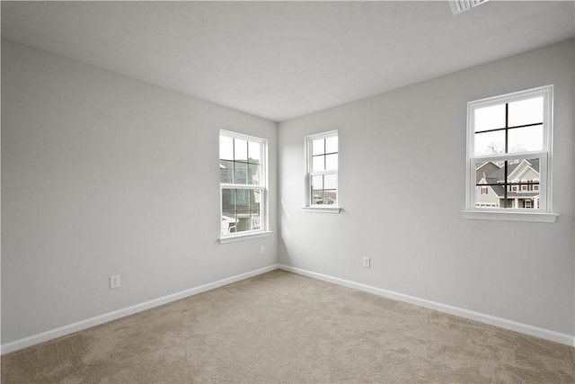 unfurnished room with carpet floors and baseboards