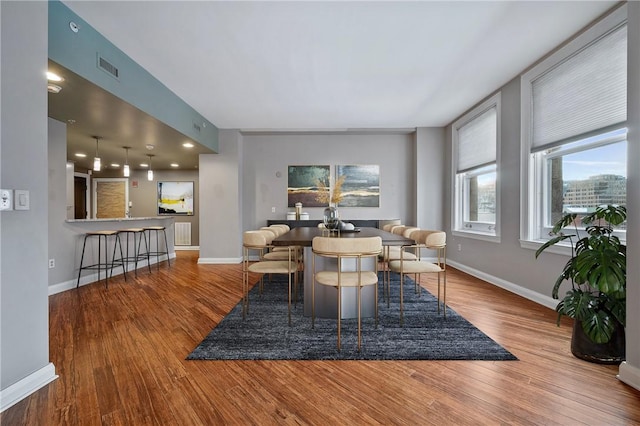 dining space featuring baseboards, visible vents, and wood finished floors