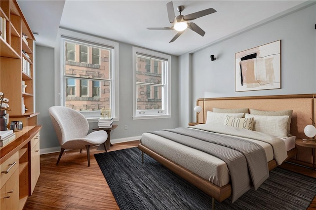 bedroom with ceiling fan, baseboards, and wood finished floors