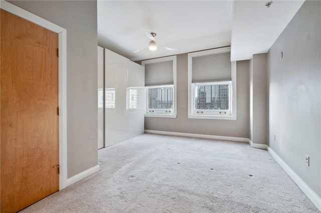 carpeted empty room featuring baseboards