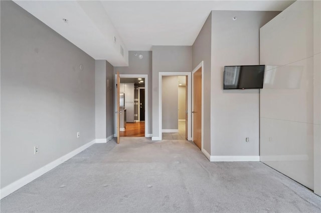 unfurnished bedroom with light carpet and baseboards