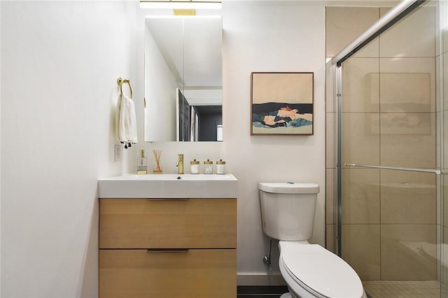 bathroom with toilet, a stall shower, and vanity