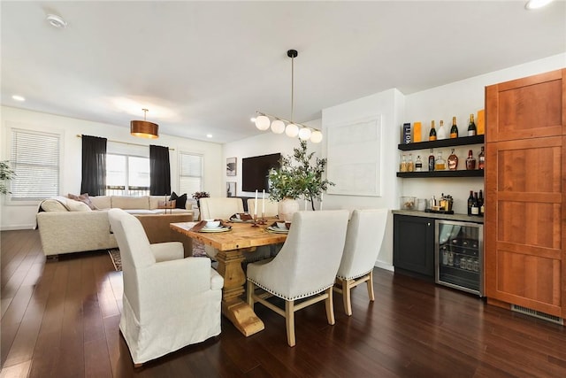 dining area featuring dark wood-style floors, beverage cooler, visible vents, and a dry bar