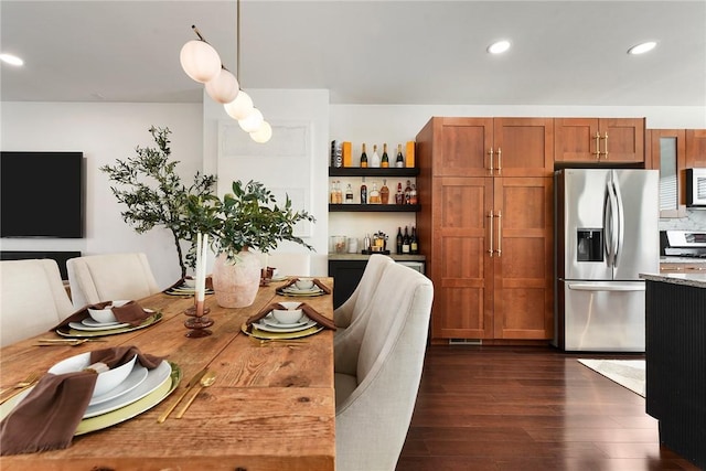 dining room with a bar, dark wood finished floors, and recessed lighting