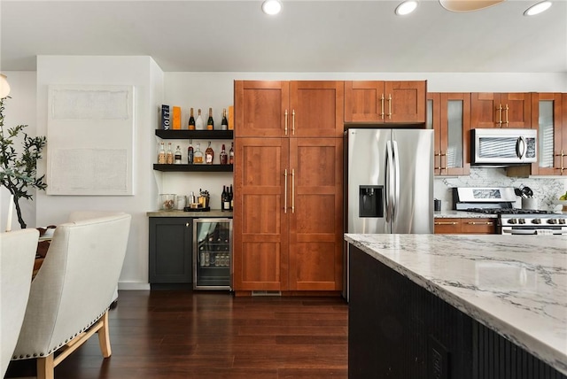 kitchen with beverage cooler, light stone counters, brown cabinets, dark wood-type flooring, and stainless steel appliances