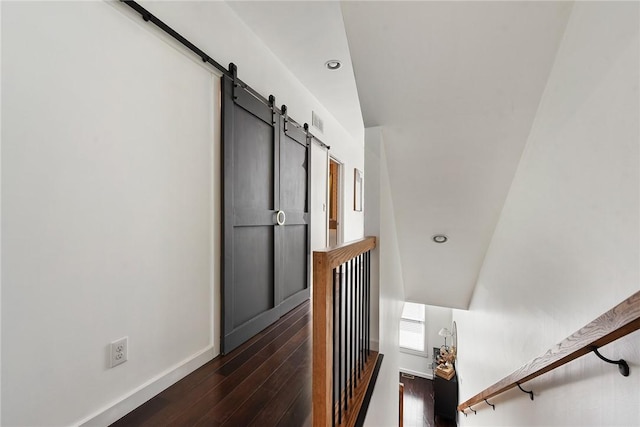 staircase with recessed lighting, wood-type flooring, baseboards, and a barn door