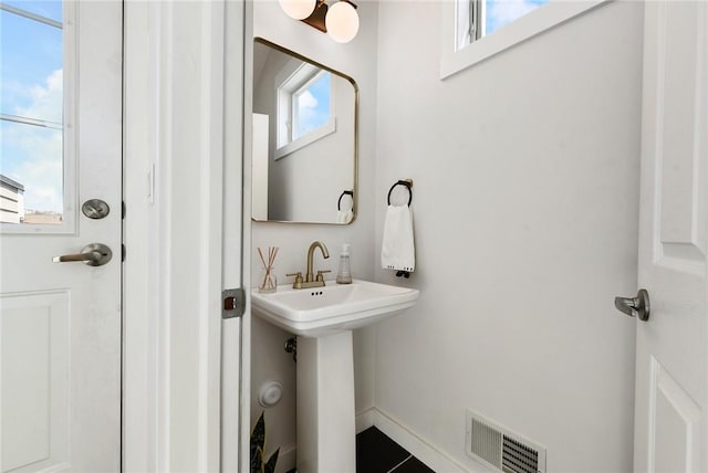 bathroom featuring visible vents, a sink, and baseboards