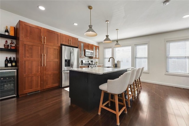 kitchen featuring beverage cooler, dark wood finished floors, a kitchen breakfast bar, stainless steel appliances, and a sink