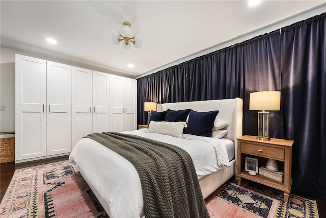 bedroom with a closet, wood finished floors, and recessed lighting