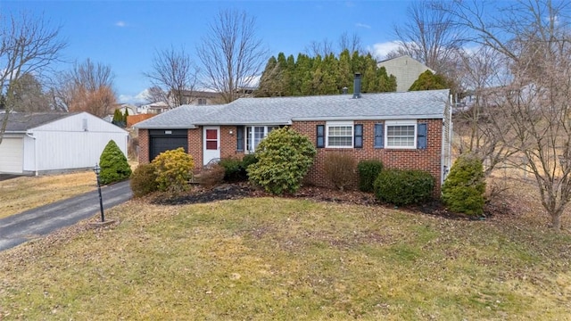 single story home with brick siding, driveway, an attached garage, and a front lawn