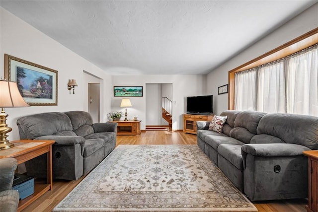 living area featuring stairway and light wood-style floors