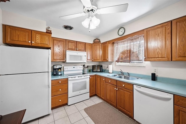 kitchen featuring white appliances, brown cabinets, and a sink