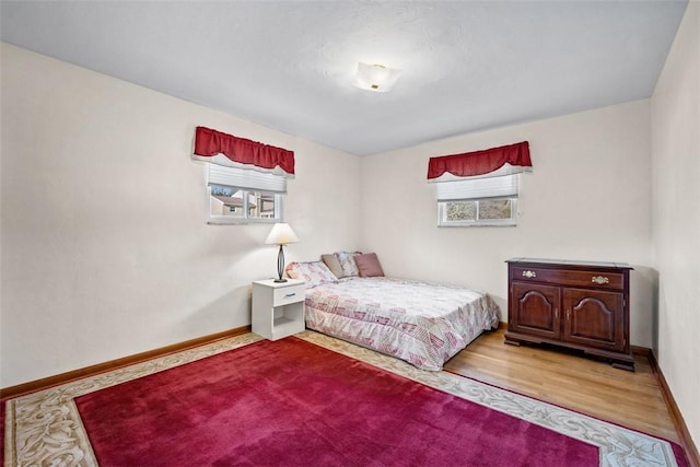 bedroom with baseboards and wood finished floors