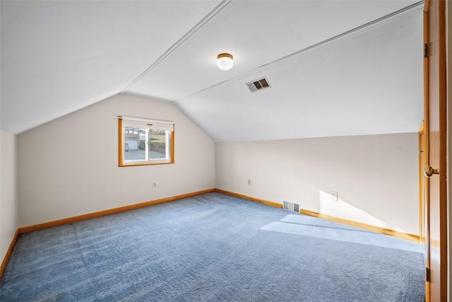 additional living space with carpet floors, visible vents, vaulted ceiling, and baseboards