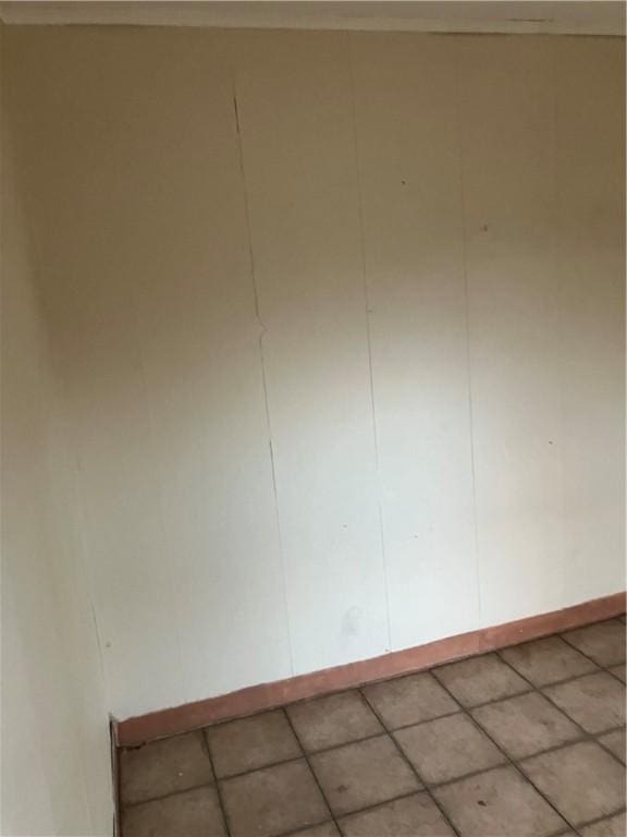 spare room with baseboards and crown molding