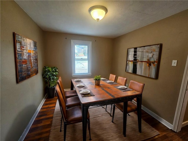 dining space with baseboards and dark wood-type flooring