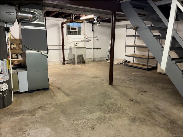 unfinished basement featuring gas water heater, a sink, stairway, and heating unit