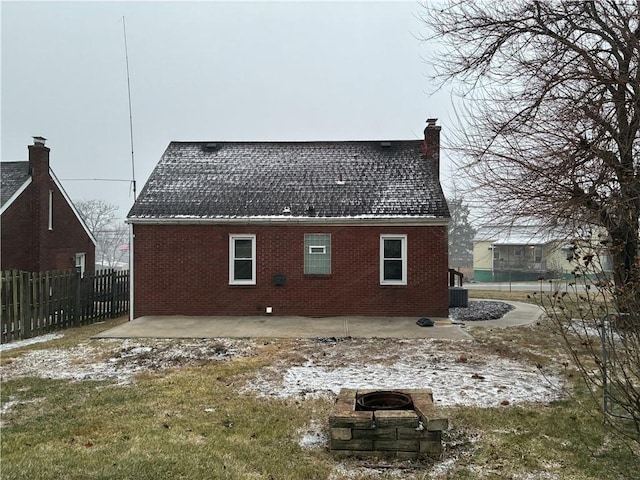 rear view of property with a patio, a chimney, fence, central air condition unit, and brick siding