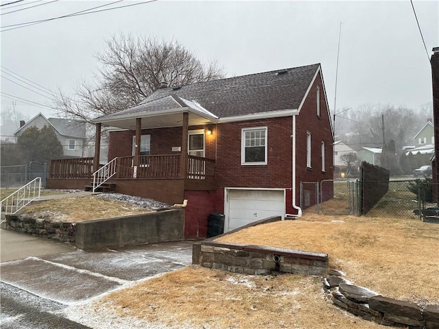 bungalow-style home with a garage, a gate, brick siding, and fence