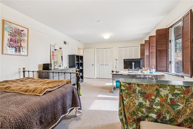 carpeted bedroom with two closets and visible vents