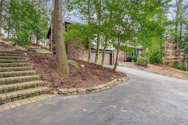 view of yard featuring driveway and a garage