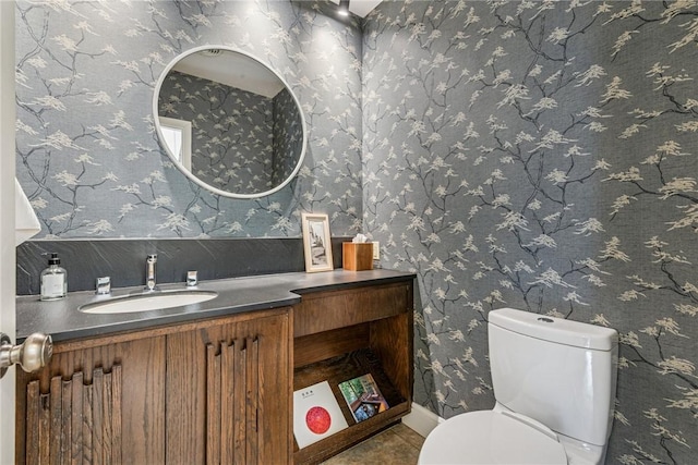 bathroom featuring vanity, toilet, and wallpapered walls