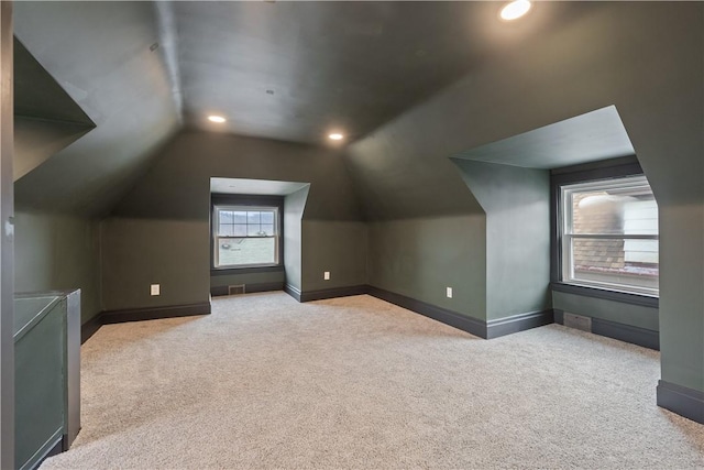 additional living space with carpet floors, lofted ceiling, and baseboards