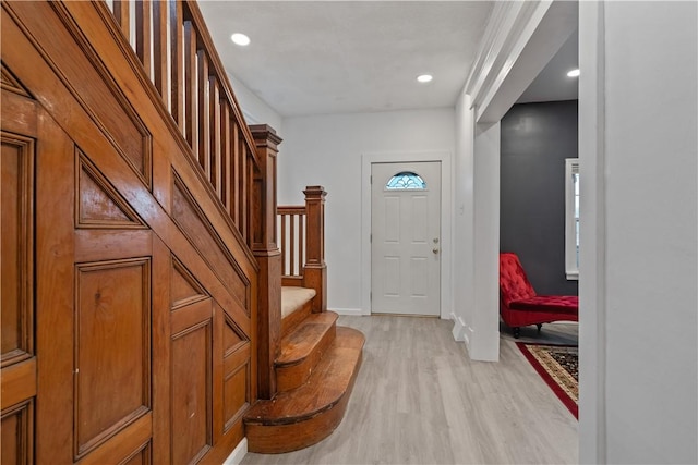 foyer entrance with recessed lighting, baseboards, light wood finished floors, and stairs