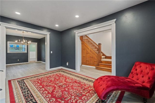 living area with a chandelier, wood finished floors, stairs, and baseboards