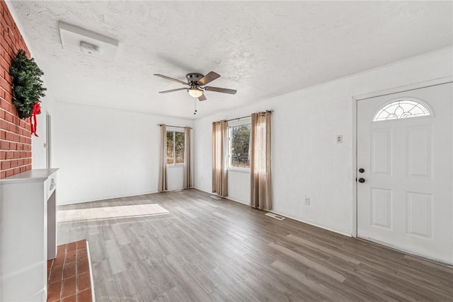 foyer with ceiling fan, a textured ceiling, and wood finished floors