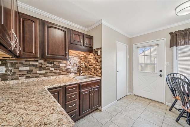 kitchen with light tile patterned floors, decorative backsplash, ornamental molding, dark brown cabinets, and a sink