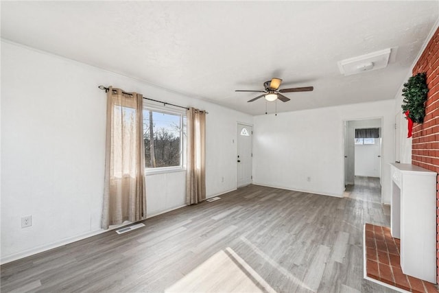 unfurnished living room featuring light wood-type flooring, visible vents, and a ceiling fan