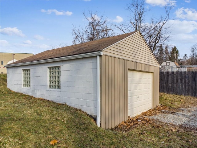 detached garage with gravel driveway and fence