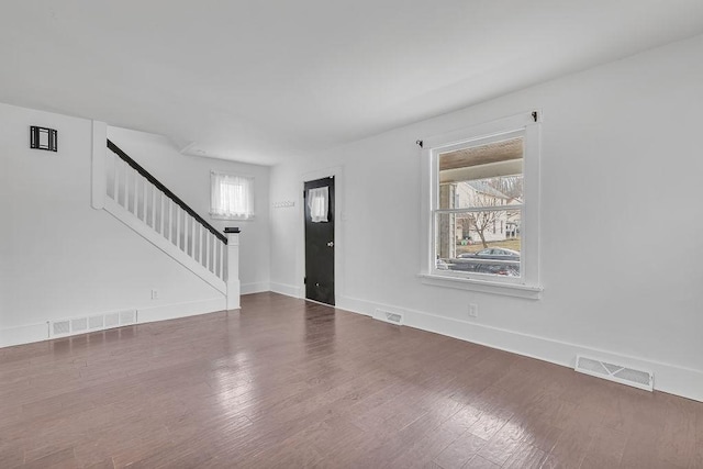 foyer entrance featuring baseboards, stairs, visible vents, and wood finished floors