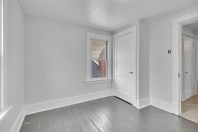 unfurnished room featuring hardwood / wood-style floors and baseboards